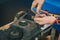 Serviceman stripping robotic lawnmower with imbus tool, motorized lawnmower being serviced on a table after a year of use in the