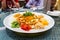 Serving of auspicious yusheng or yee sang with abalone in restaurant during Chinese New Year celebration with diners