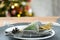 Serving a festive table with plates, forks, knives, napkins close-up tissue in a cage decorated for Christmas and New Year pine