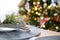 Serving a festive table with plates, forks, knives, napkins close-up tissue in a cage decorated for Christmas and New Year pine