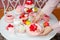Serving festive table of sweet desserts, fresh strawberry and raspberry, tasty drinks. Person hand hold plate of