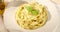 Serving Fettuccine pasta with pesto sauce on a plate. angle view.