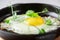 Serving fried eggs in cast iron pan microgreen sprouts baby beans pea and sunflower on white background