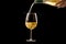 Serving a glass of white wine on a black background