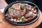 Serving grilled beef steak with beans close-up on a plate on a table.