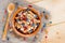 Serving muesli scattering of wild berries, nuts on wooden table