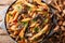 Serving penne pasta with roasted honey mushrooms and tomato sauce close-up in a plate. Horizontal top view