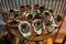 Serving row of fresh delicious oysters in shells on round plate in restaurant closeup top view. Portion of seasonal