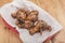 A serving of Spicy Korean Chicken wings at a restaurant. On a tray covered with greaseproof paper