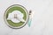 Serving table set with green plate and napkin, golden fork and knife