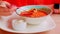 Serving thai soup on table. Unrecognizable woman eating spicy tom yam soup in restaurant. Food concept. Close up.