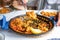 Serving typical Spanish paella with squid in restaurant