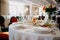 Serving the wedding table. Restaurant business. Glasses, white plates and cutlery on a round table decorated with roses in a white