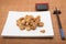 Sesame chicken dish and chopsticks on bamboo placemat