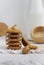 Sesame cookies on a white plate, sesame seeds in a wicker basket, rough woven tablecloth