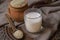 Sesame milk in glass and sesame seed in clay pot on a table.