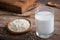 Sesame milk in glass and white sesame seeds on wooden plate