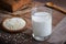 Sesame milk in glass and white sesame seeds on wooden plate