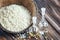 Sesame oil in a glass bottle and heap sesame seeds in coconut shell on wooden rustic table. Selective focus.