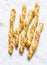 Sesame puff pastry breadsticks on a light background, top view. Delicious snack, tapas