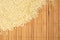 Sesame seeds scattered on wooden mat in the corner