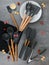 A set of accessories for the kitchen in black. Ladle, spoon, skimmer, mesh skimmer, spatula, slotted spatula, brush, whisk, tongs