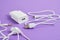 Set of accessories for smartphone, charger and earphones on purple background copy space