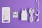 A set of accessories for a smartphone, charger, headphones, holding a ring, adapters for sim cards on a purple background copy
