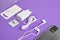 A set of accessories for a smartphone, phone, charger, headphones, a ring-holder, adapters for SIM cards on a purple background