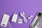 A set of accessories for a smartphone, phone, charger, headphones, a ring-holder, adapters for SIM cards on a purple background