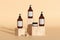 Set of amber colored liquid soap and cream bottles with blank label on wooden podiums