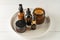Set of amber glass cosmetic bottles on a plate on wooden background. Natural cosmetics unbranded packaging design