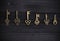 set of antique copper keys lie in a row on a black wooden background.
