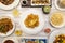 Set of Asian Chinese food recipes on white plates, lemon battered chicken, fried gyozas with soy sauce, duck with orange and fried