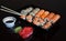 Set with an assortment of fresh Japanese rolls with fish. Roll with rice and sesjut. Japanese rolls on black background