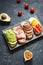 A set of avocado sandwiches, cherry tomatoes and eggs, figs, prochutto on a stone background.