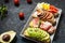 A set of avocado sandwiches, cherry tomatoes and eggs, figs, prochutto on a stone background