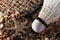 Set Badminton racket and shuttlecock feathers on rocks, beach background.