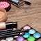 Set of basic make-up products on wooden surface