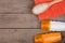 Set of bathing accessories - orange towel, hairbrush and cosmetics for pampering on brown wooden background