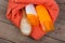 Set of bathing accessories - orange towel, hairbrush and cosmetics for pampering on brown wooden background