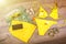 Set of beach clothes yellow bikini, bracelets, shorts, glasses on dark wooden background. Top view. Summer Holiday