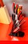 Set of beautiful metal kitchen knives on a red background