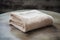 A set of beige bath terry towels on a wooden table