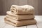 A set of beige bath terry towels on a wooden table