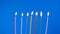 A set of birthday candles burning brightly against a blue background. Close-up shot of birthday candle flames