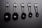 A set of black measuring spoon on black background