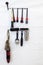 A set of black and red brushes hanging on a shelf on a white wall, a set of tools for working in a car workshop for painting,