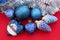 Set of blue Christmas tree decorations. blue christmas tree toys on red background with place for text. Glass toy heart. Shiny bal