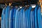 Set of blue color soft surfboards in a stack by ocean.Bali.Indonesia. Surf boards on sandy beach for rent. Surf lessons on